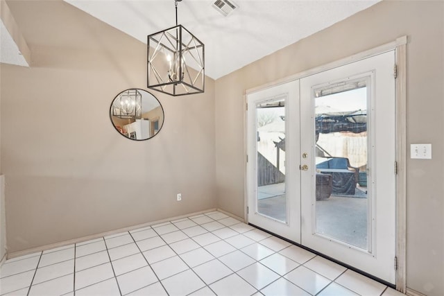 doorway to outside featuring a notable chandelier, french doors, and light tile patterned flooring