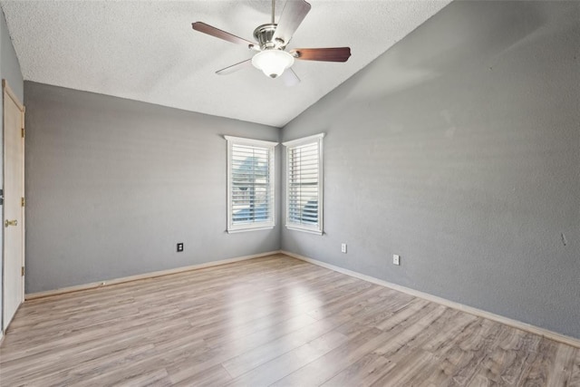 empty room featuring lofted ceiling, a textured ceiling, ceiling fan, and light hardwood / wood-style flooring