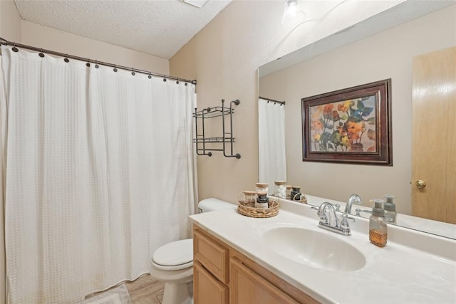 bathroom featuring vanity, toilet, hardwood / wood-style floors, and a textured ceiling