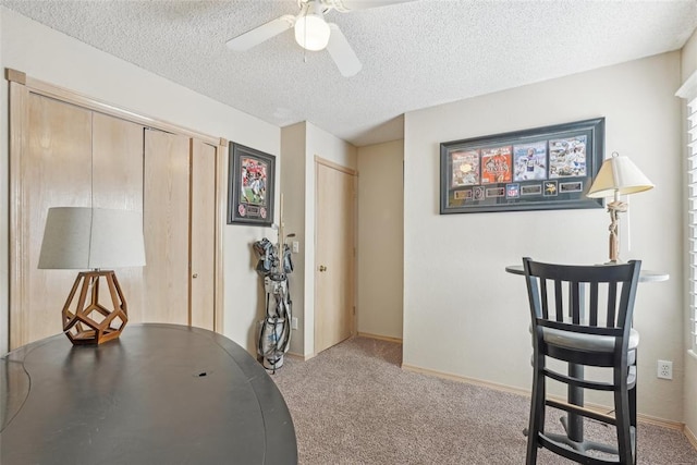 office area with ceiling fan, light carpet, and a textured ceiling