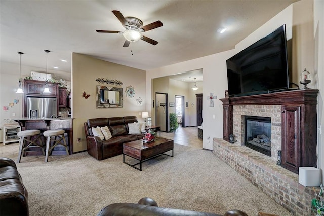 carpeted living room with a brick fireplace and ceiling fan