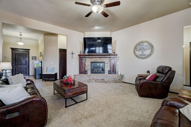 carpeted living room with ceiling fan and a brick fireplace