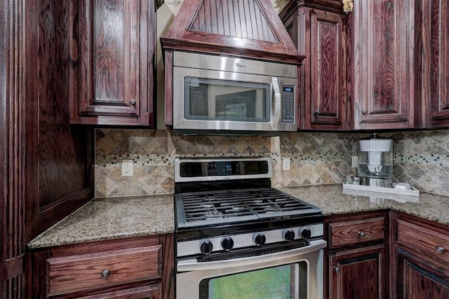 kitchen featuring tasteful backsplash, light stone countertops, and appliances with stainless steel finishes