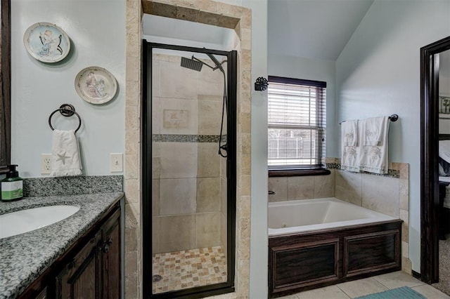 bathroom with vanity, vaulted ceiling, tile patterned floors, and plus walk in shower