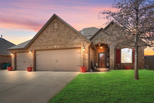 view of front of home with a garage and a yard