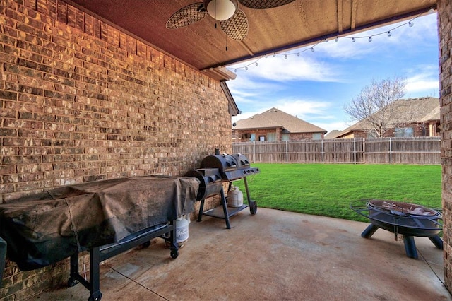 view of patio / terrace with a fire pit, grilling area, and ceiling fan