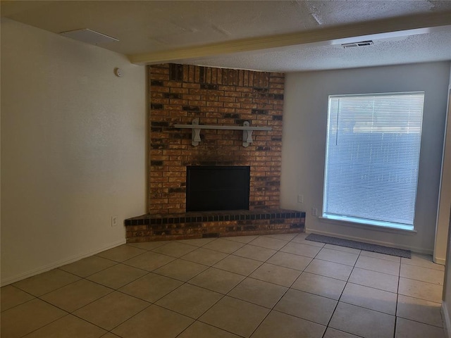 unfurnished living room featuring beam ceiling, a brick fireplace, a textured ceiling, and light tile patterned floors