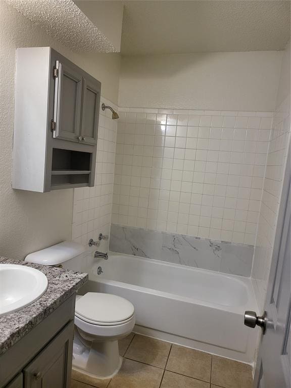 full bathroom featuring vanity, tile patterned floors, toilet, and tiled shower / bath