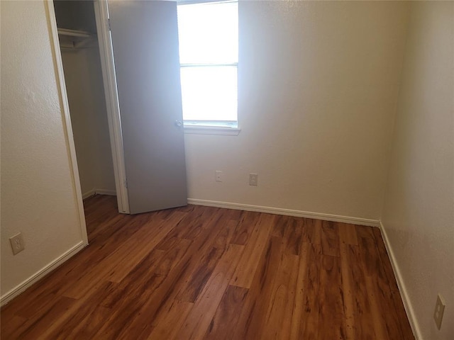 unfurnished bedroom with dark hardwood / wood-style floors and a closet