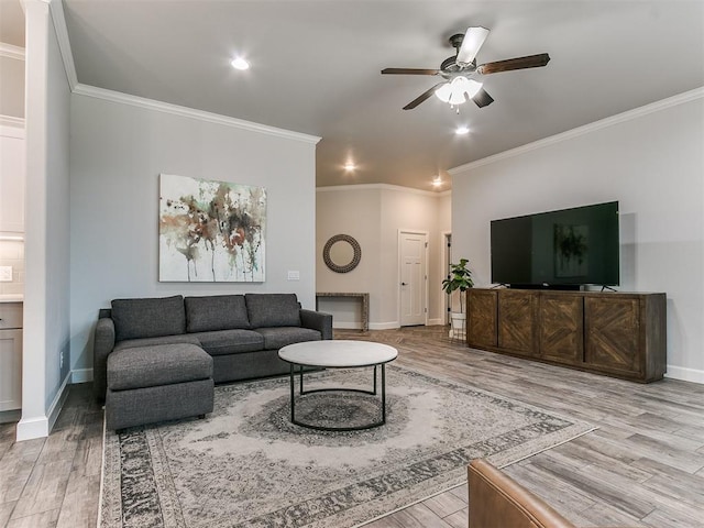 living room featuring crown molding, ceiling fan, and light hardwood / wood-style flooring