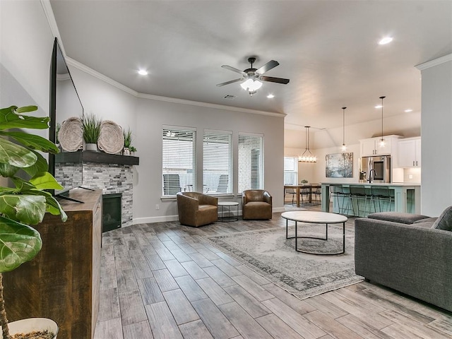 living room with ornamental molding, a fireplace, and light hardwood / wood-style floors