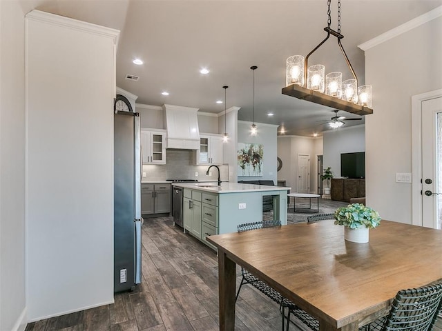 dining space featuring dark hardwood / wood-style flooring, sink, crown molding, and ceiling fan