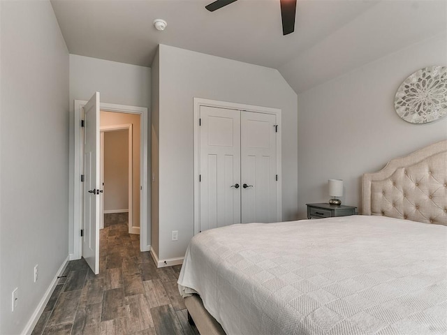 bedroom featuring vaulted ceiling, dark wood-type flooring, ceiling fan, and a closet