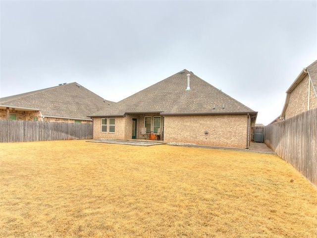 rear view of house featuring a yard and a patio