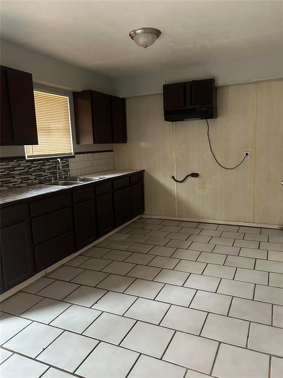 kitchen with sink, decorative backsplash, and dark brown cabinets