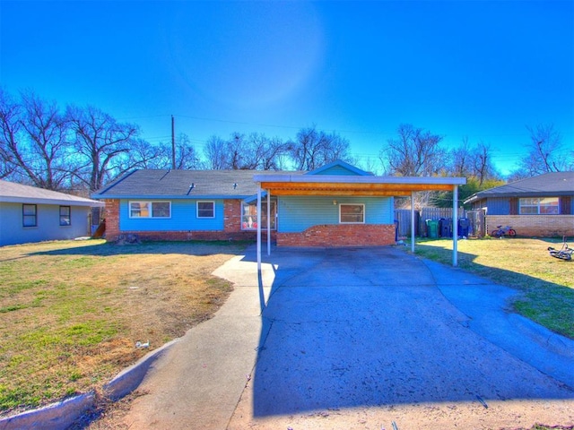 view of front of house with fence, a front lawn, concrete driveway, and brick siding