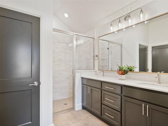 bathroom with a sink, a shower stall, and double vanity