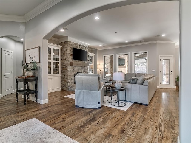 living room with a fireplace, ornamental molding, and dark hardwood / wood-style flooring