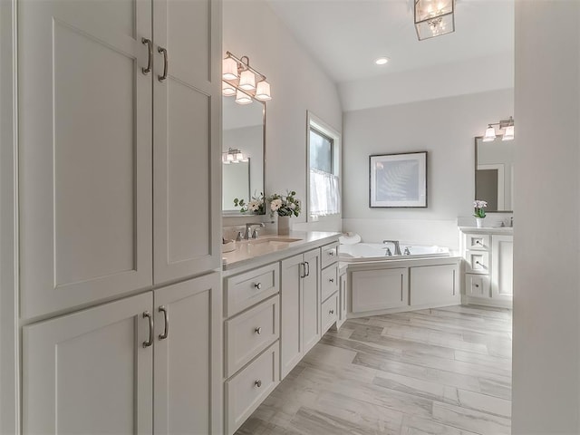 bathroom with a tub to relax in and vanity