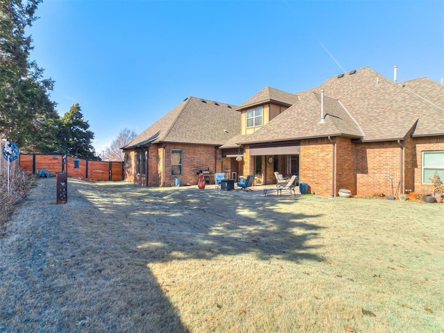 back of property with a yard and a patio area