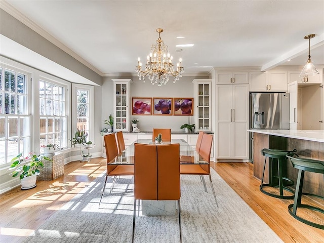 dining area featuring an inviting chandelier, crown molding, and light wood-type flooring