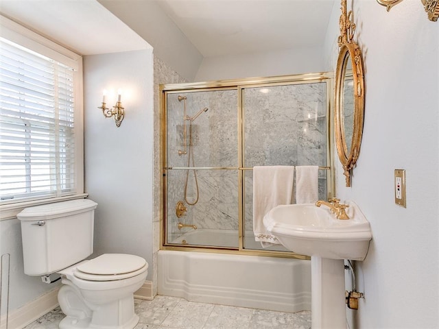 bathroom featuring enclosed tub / shower combo and toilet