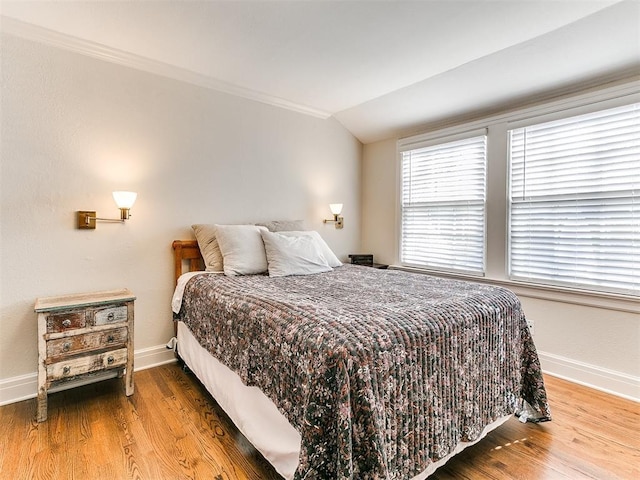 bedroom with wood-type flooring and vaulted ceiling