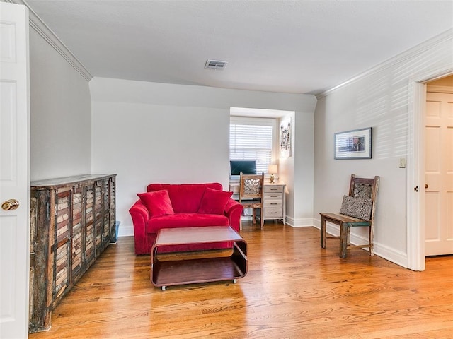 sitting room with crown molding and hardwood / wood-style flooring