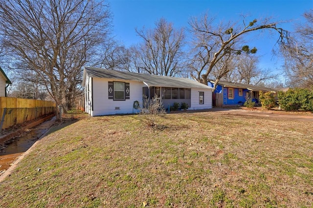 ranch-style home featuring a sunroom and a front yard