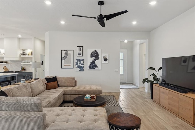 living room with ceiling fan and light hardwood / wood-style flooring