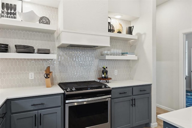 kitchen with gas stove, decorative backsplash, and gray cabinetry