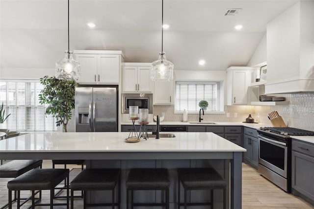 kitchen with a kitchen island, white cabinetry, appliances with stainless steel finishes, and gray cabinetry