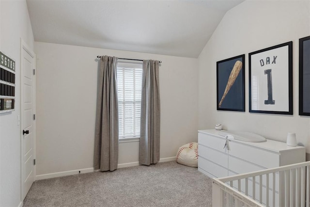 carpeted bedroom featuring vaulted ceiling and a nursery area