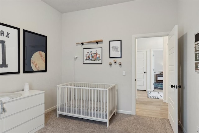 bedroom with a nursery area and carpet