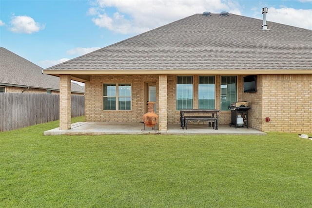 rear view of property with a yard and a patio area