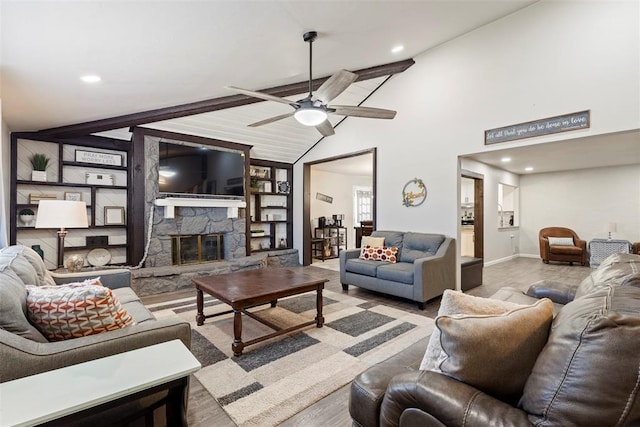 living room featuring vaulted ceiling, a stone fireplace, and ceiling fan