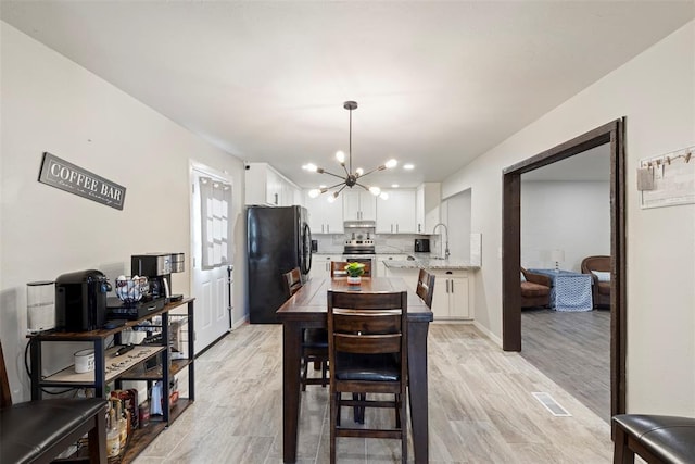 dining space featuring a chandelier and light hardwood / wood-style flooring