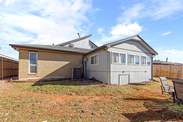 back of property with a yard and central air condition unit