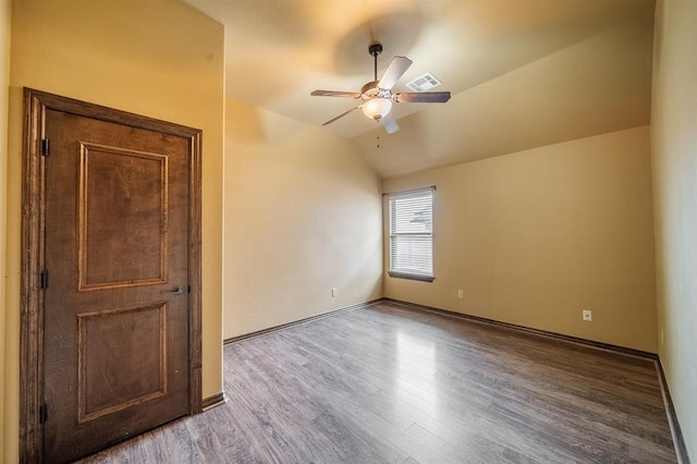 empty room featuring ceiling fan, vaulted ceiling, and wood-type flooring