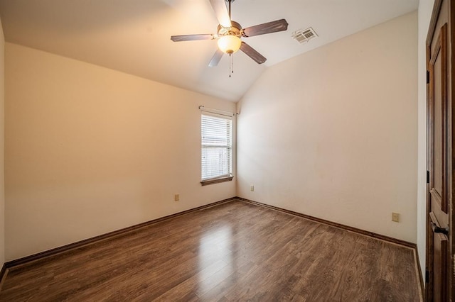 empty room featuring vaulted ceiling, dark wood-type flooring, and ceiling fan