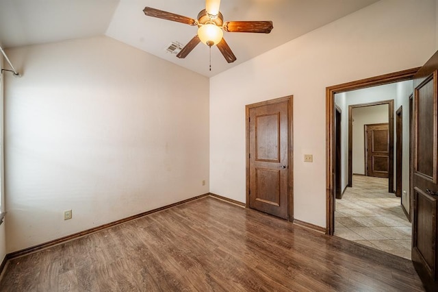 unfurnished bedroom with lofted ceiling, light wood-type flooring, and ceiling fan