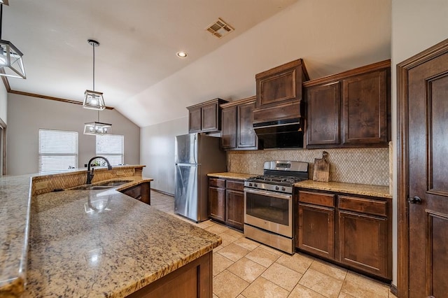 kitchen featuring tasteful backsplash, decorative light fixtures, vaulted ceiling, stainless steel appliances, and light stone countertops