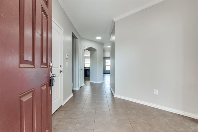 tiled foyer featuring crown molding