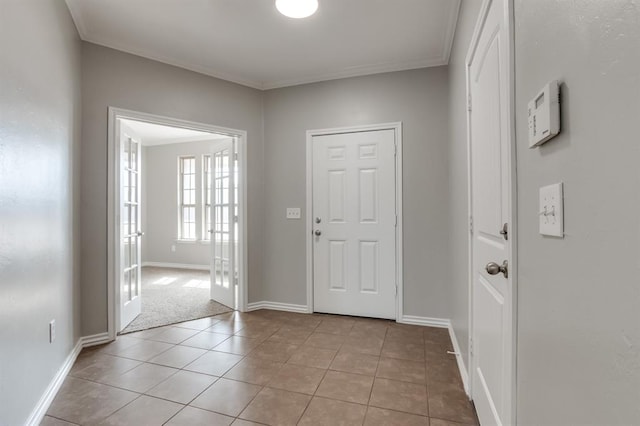 tiled foyer entrance with crown molding and french doors