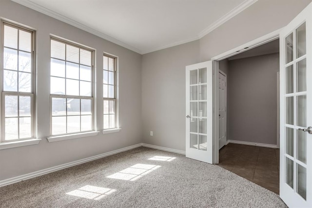 carpeted spare room with crown molding and french doors