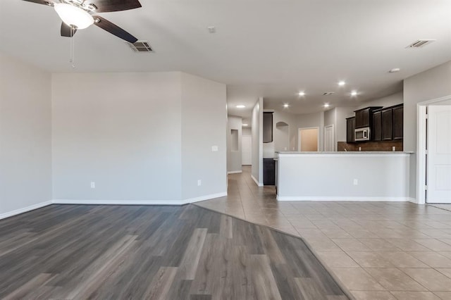 unfurnished living room featuring hardwood / wood-style flooring and ceiling fan