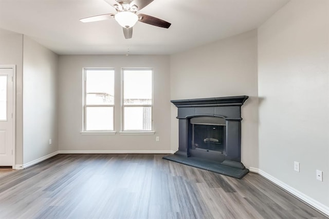 unfurnished living room featuring wood-type flooring and ceiling fan