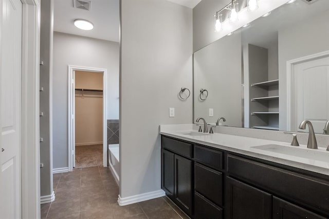 bathroom featuring vanity, tile patterned flooring, and a washtub