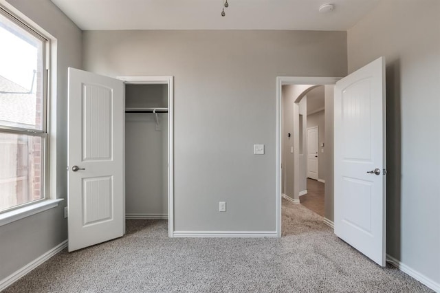 unfurnished bedroom with a closet and light carpet