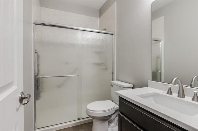 bathroom with vanity, toilet, tile patterned flooring, and a shower with door